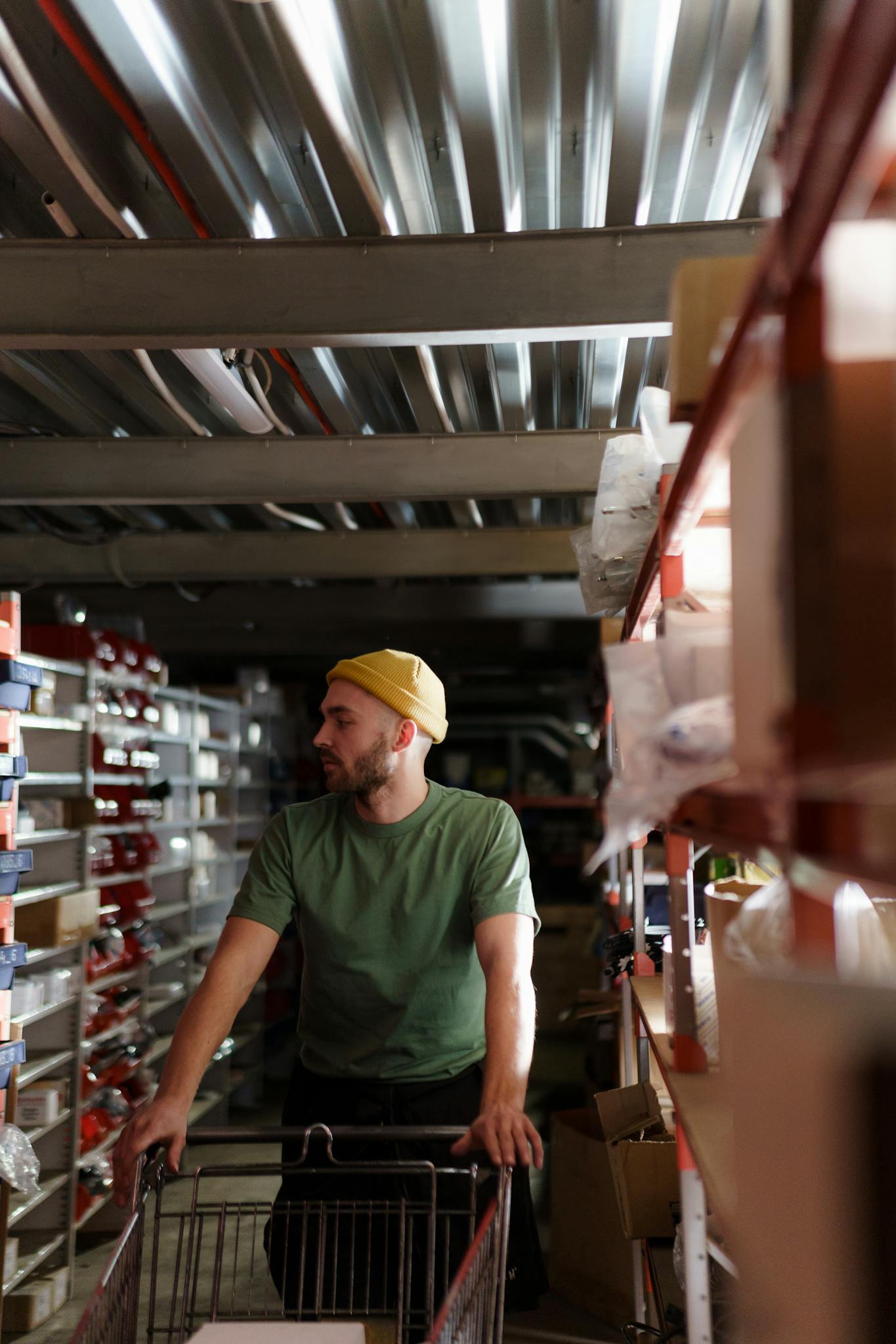 A focused warehouse worker organizing shelves in a storeroom, showcasing work efficiency.